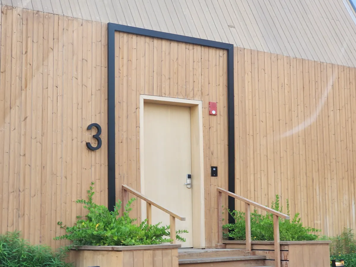 The wooden front door of villa number 3 at Katara Hills in Doha